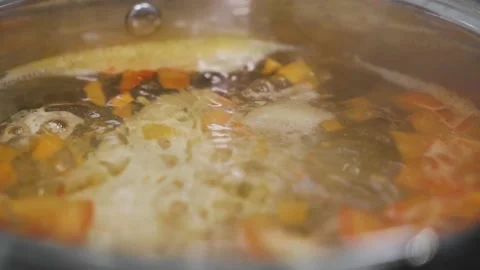 Broth is boiling in a pot. The process of making soup at home in the kitchen Video stock 143712360