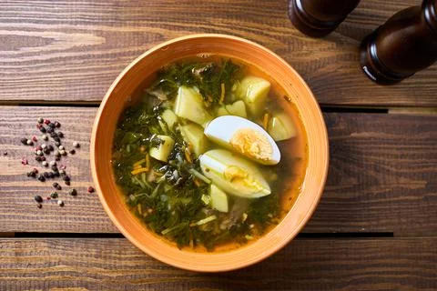 Broth with egg and bread with sour cream Stock Photos