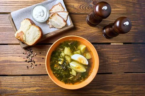 Broth with egg and bread with sour cream Stock Photos