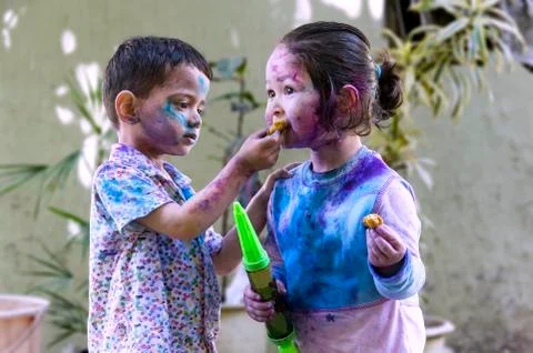 Brother and sister celebrating Holi. Stock Photos