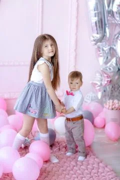 Brother and sister children on birthday in children's room decorated with pink Stock Photos
