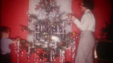 Brother and sister decorating Christmas tree 1950s vintage film home movie 3649 Stock Footage