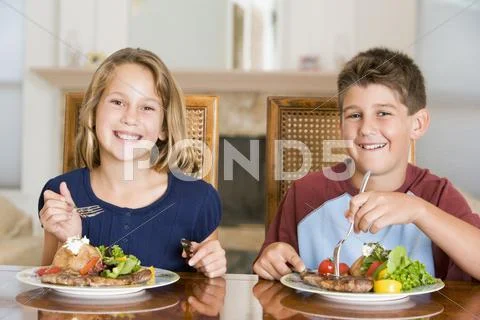 Brother and sister eating meal,mealtime together Stock Photos