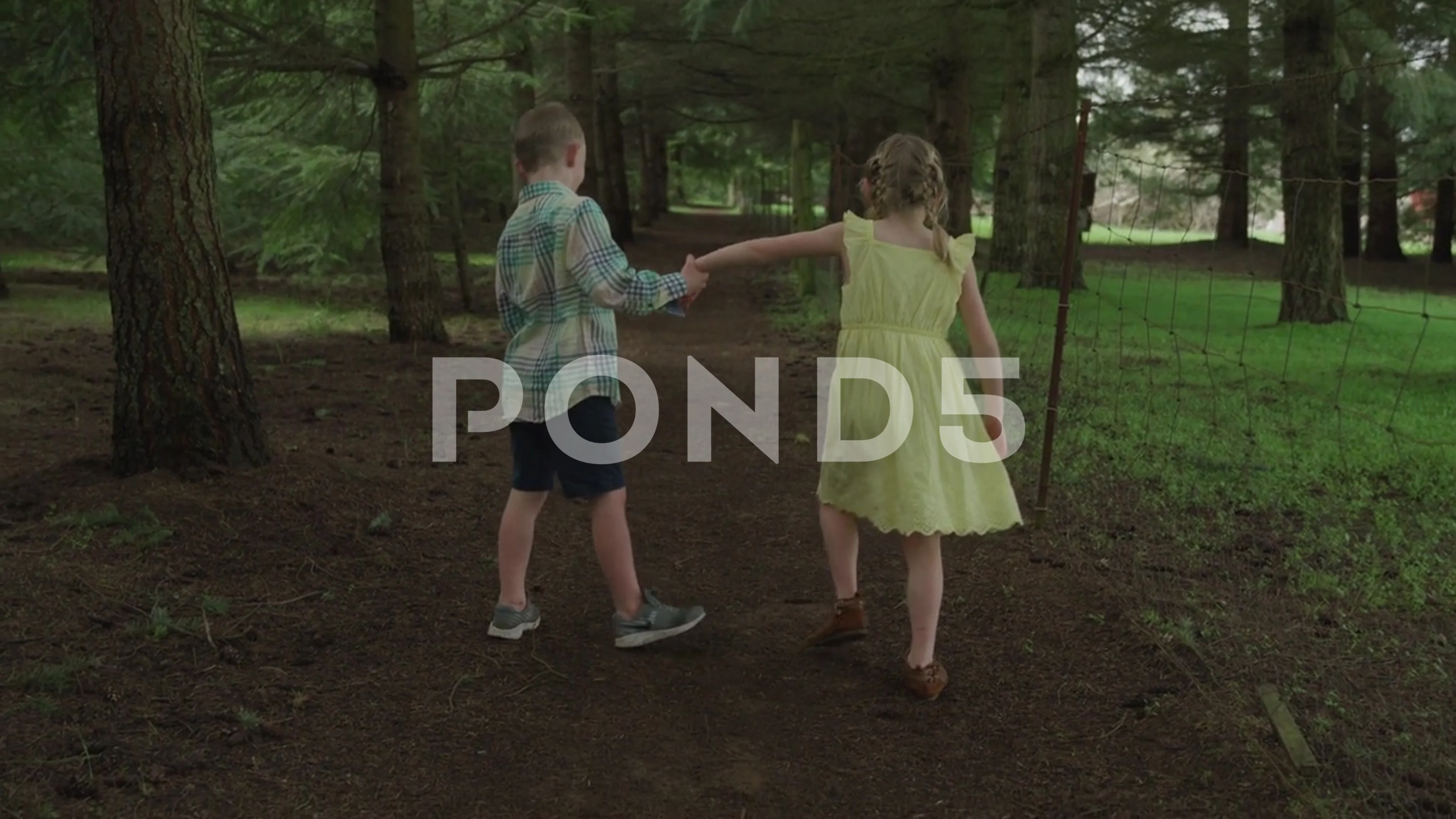 Brother and Sister Have Fun Walking Down Forest Path Holding Hands