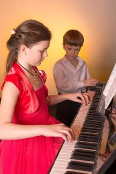 Brother And Sister Playing Piano. Piano player. Stock Photos
