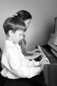 Brother And Sister Playing Piano. Piano player. Stock Photos