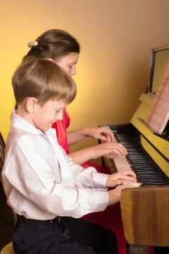 Brother And Sister Playing Piano. Piano player. Stock Photos