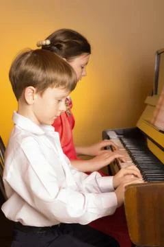 Brother And Sister Playing Piano. Piano player. Stock Photos