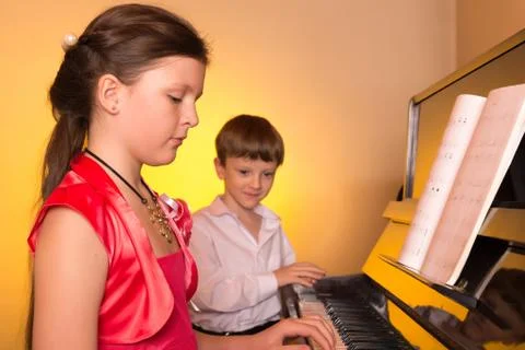 Brother And Sister Playing Piano. Piano player. Stock Photos