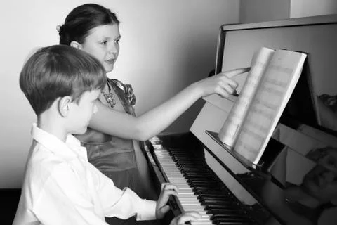 Brother And Sister Playing Piano. Piano player. Stock Photos