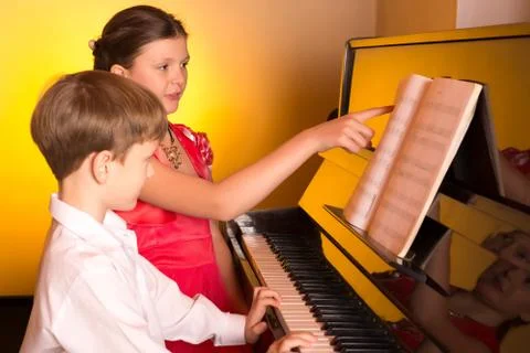 Brother And Sister Playing Piano. Piano player. Stock Photos