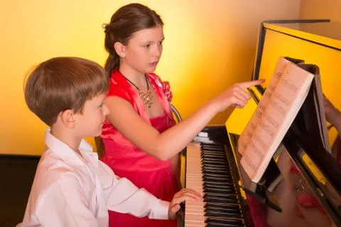 Brother And Sister Playing Piano. Piano player. Stock Photos