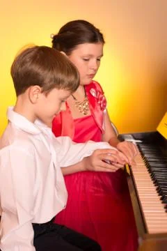 Brother And Sister Playing Piano. Piano player. Stock Photos
