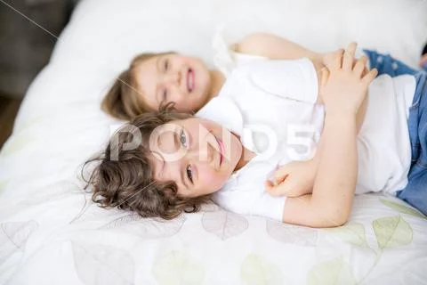 Brother And Sister Relaxing Together In Bed Stock Photos