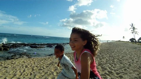 Brother and sister running while holding hands on a beach. 스톡 동영상 88371926