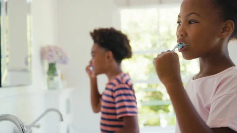 Brother And Sister Sitting In Bathroom At Home Brushing Teeth Together Stock Footage 242923853