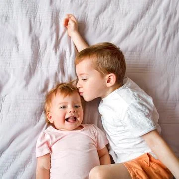 Brother kisses sister laughs, small children top view Stock Photos