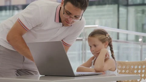 Brother wearing glasses while teaching his sister to use wireless technology Stock Footage 235487399