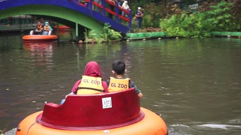 Brothers and sisters playing bumper boat in the pool 库存影片 213964815