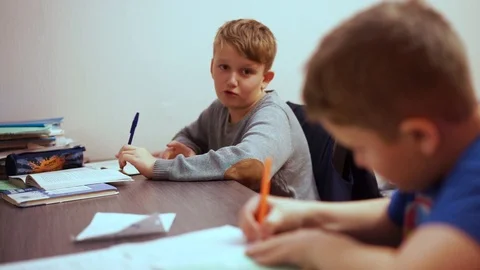 The brothers do their boring homework. They like to talk to each other more. Stock Footage 99468534