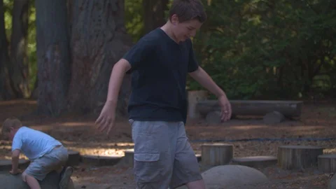 Brothers Jumping in Between Rocks Stock Footage 91590206