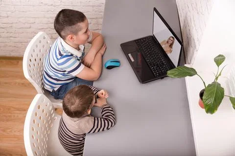 Brothers looking at laptop while e-learning. Boys using digital table Foto stock