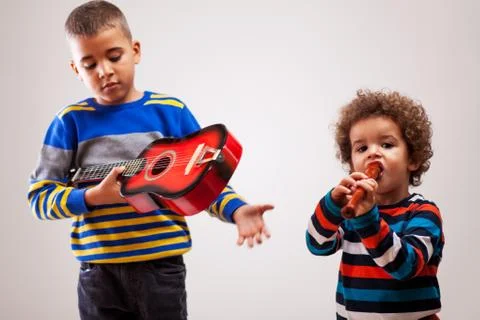 Brothers playing on instruments Stock Photos