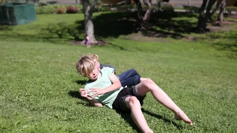 Brothers Rolling Down Hill at La Brea Tarpits Museum in LA Stock Footage 272871425