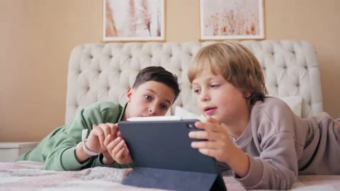 Brothers with tablet computer in light room. Children, boys playing games on Stock Footage 139362211