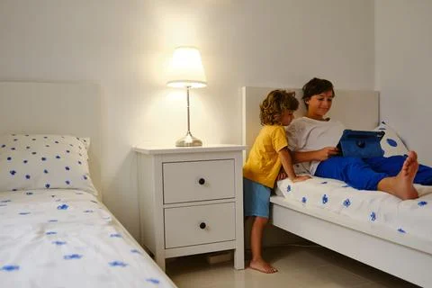 Brothers using tablet in bedroom Stock Photos