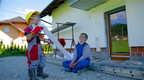 Brothers in work suits playing in front of house Stock Footage 42321989