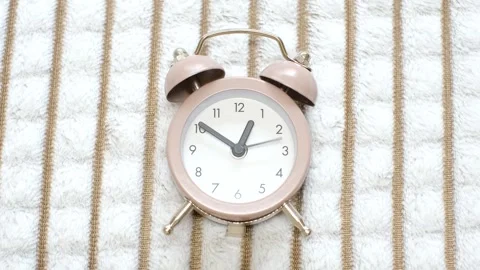 Brown alarm clock against the background of a crumpled plush blanket, top view Stock Footage 321119839