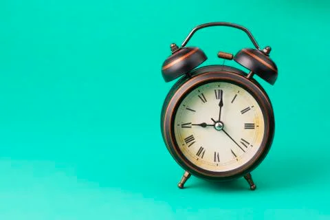 Brown alarm clock on a green background Stock Photos