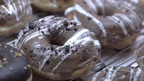 Brown and black donuts inside a shop window Stock Footage 265789311