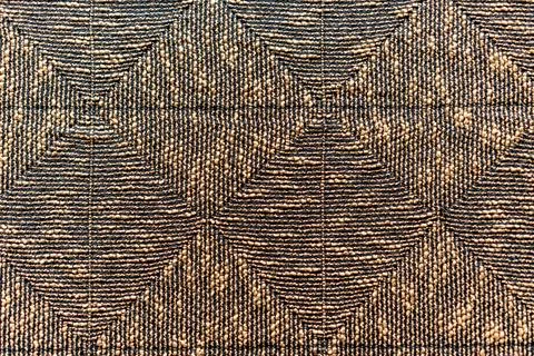 A brown and black patterned rug with a diamond shape design Foto stock