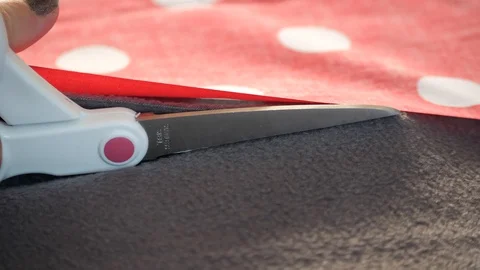 Brown and polka dot material is cut with scissors 動画素材 129517534