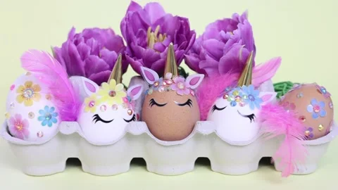 Brown and white Easter eggs decorated in the form of unicorns on a green and Stock Footage 149513892