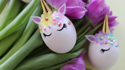 Brown and white Easter eggs decorated in the form of unicorns on a green and Stock Footage 149513921