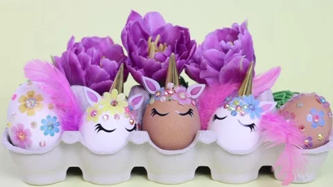 Brown and white Easter eggs decorated in the form of unicorns on a green and Stock Footage 149519369