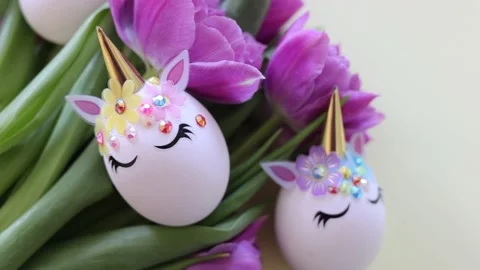 Brown and white Easter eggs decorated in the form of unicorns on a green and Stock Footage 149519630