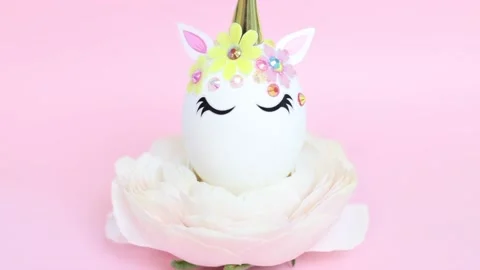 Brown and white Easter eggs decorated in the form of unicorns on a green and Stock-Footage 149754486