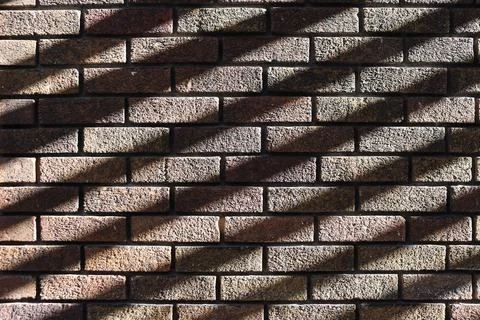 An brown background with old bricks and linear shadow Stock Photos