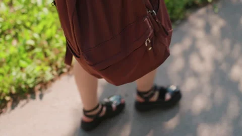 Brown backpack view while walking along grassy verge, zipper and fabric details Stock Footage 323512964