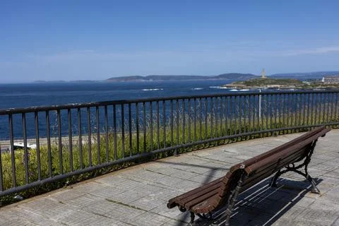 Brown bench overlooking the ocean. Stock Photos