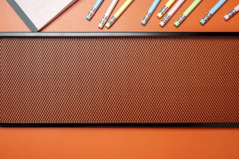 A brown board with a pattern on it and a bunch of pencils on it 스톡 사진