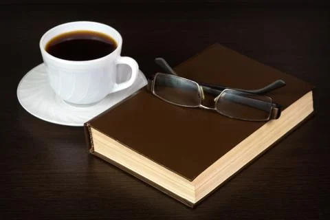 Brown book with glasses on a table Stock Photos