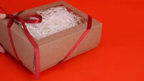 Brown box with a gift on a red background. Holiday concept. Stock Footage 169598278
