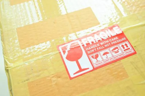 Brown box packaging with warning symbol Stock Photos