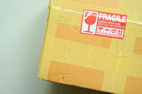 Brown box packaging with warning symbol Foto stock