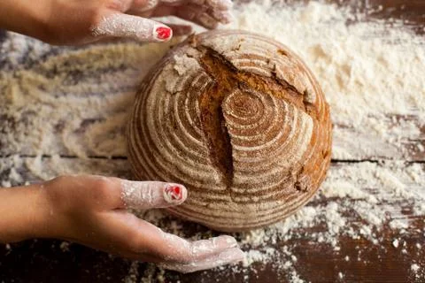 Brown bread in hands Stock Photos